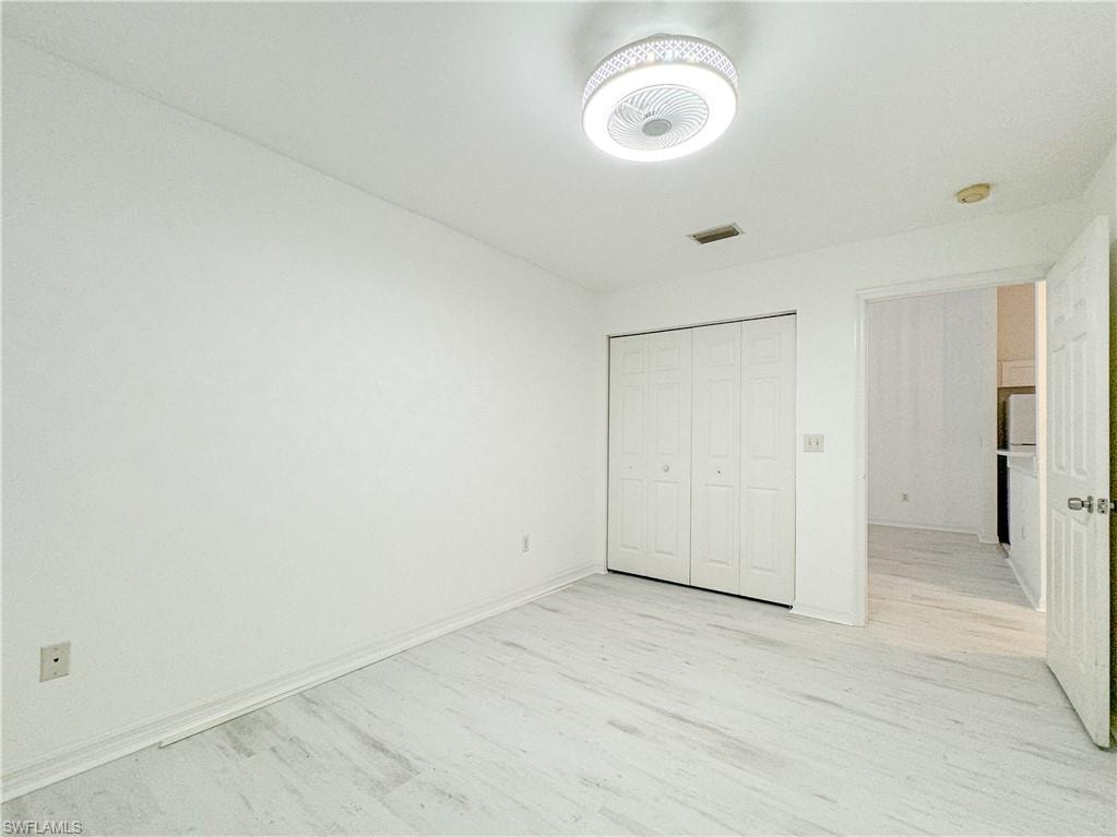 Unfurnished bedroom featuring light hardwood / wood-style floors and a closet