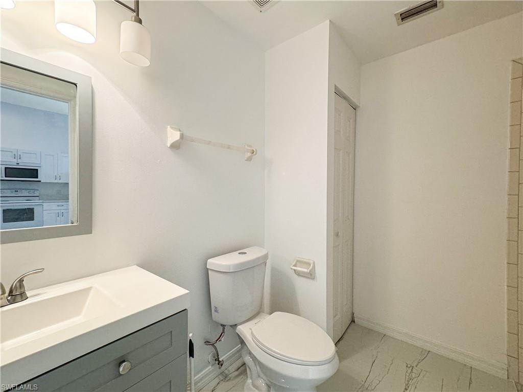 Bathroom featuring tile patterned floors, toilet, and vanity