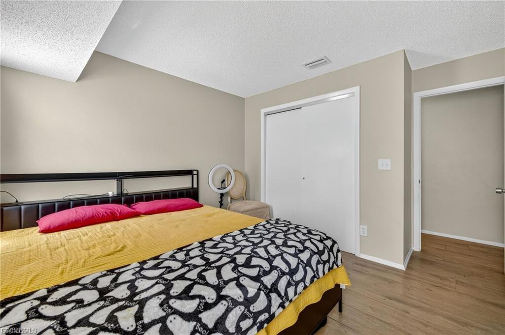 Interior room featuring wood-finish flooring, a white sliding closet door, and light-toned wall paint