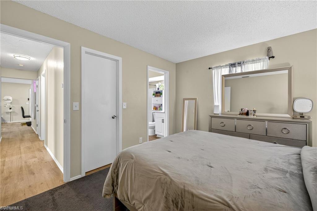 Neutral tone wall paint with white trim, a window with a sheer curtain, and an entryway with wood-finish flooring