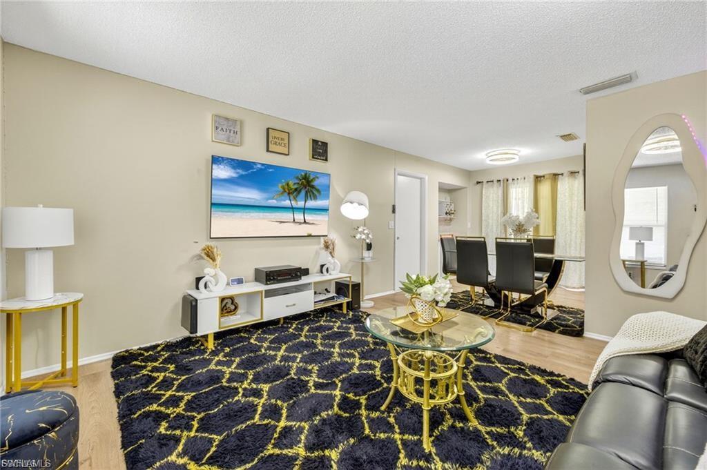 Open-concept living area featuring wood-finish flooring and a neutral color palette
