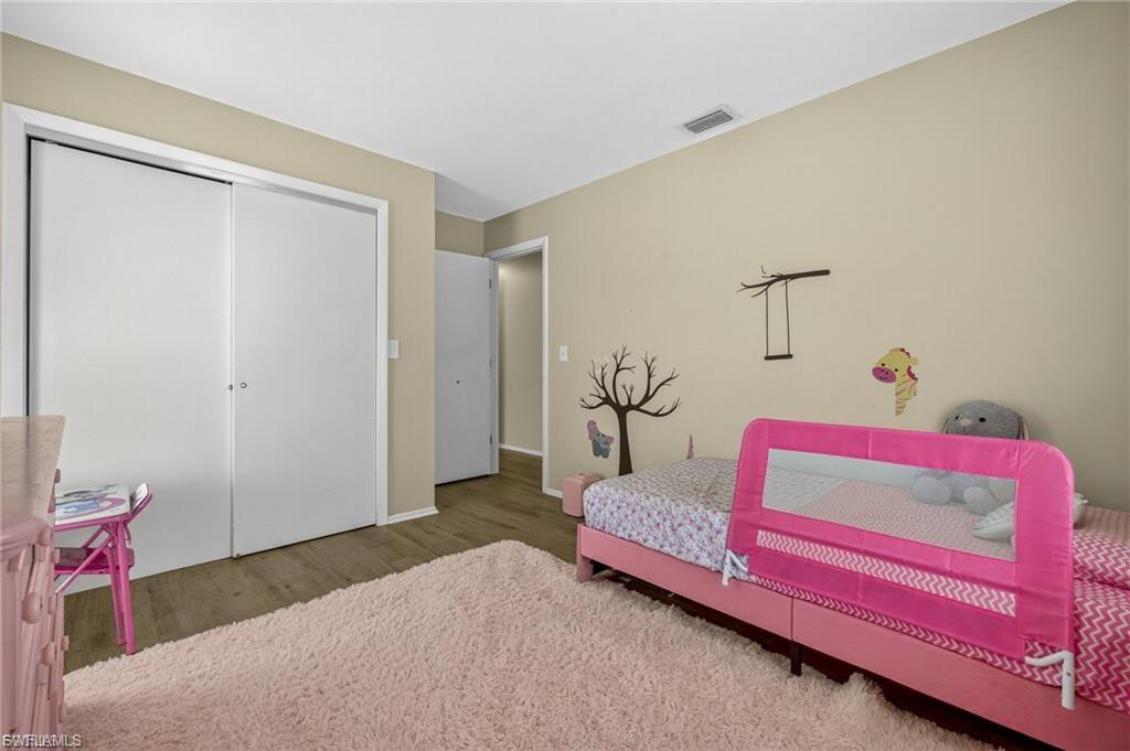 Neutral wall paint with white trim, wood-finish flooring, and white bi-fold closet doors
