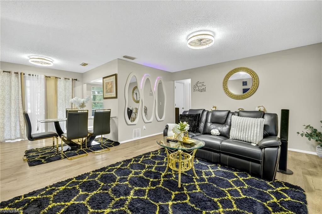 Spacious living area featuring wood-finish flooring, neutral wall tones, and recessed lighting