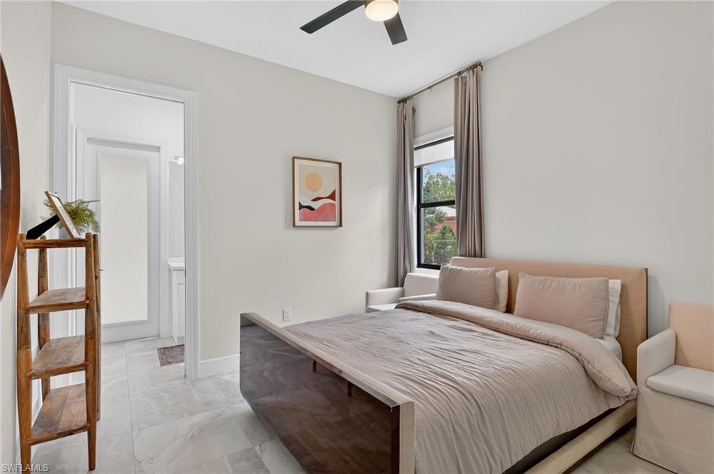 Bedroom featuring light gray wall paint, a ceiling fan with integrated lighting, a window with curtains, and light-toned tile flooring