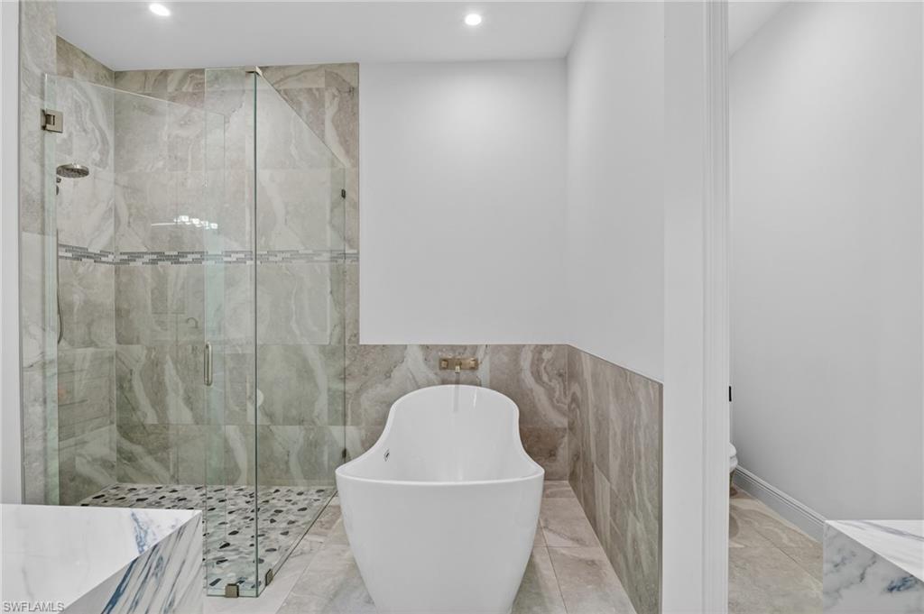 Contemporary bathroom featuring a freestanding tub and a glass-enclosed shower