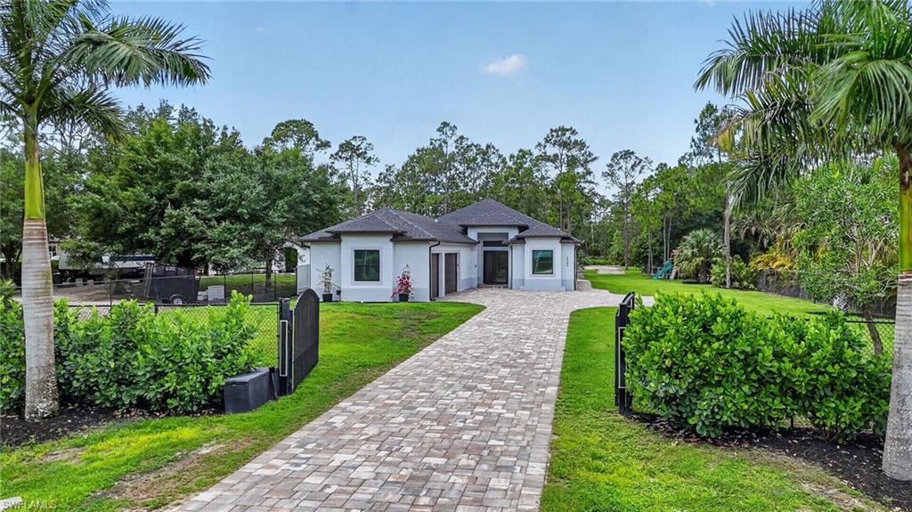 Contemporary single-story residence with a dark shingle roof and light-colored stucco exterior