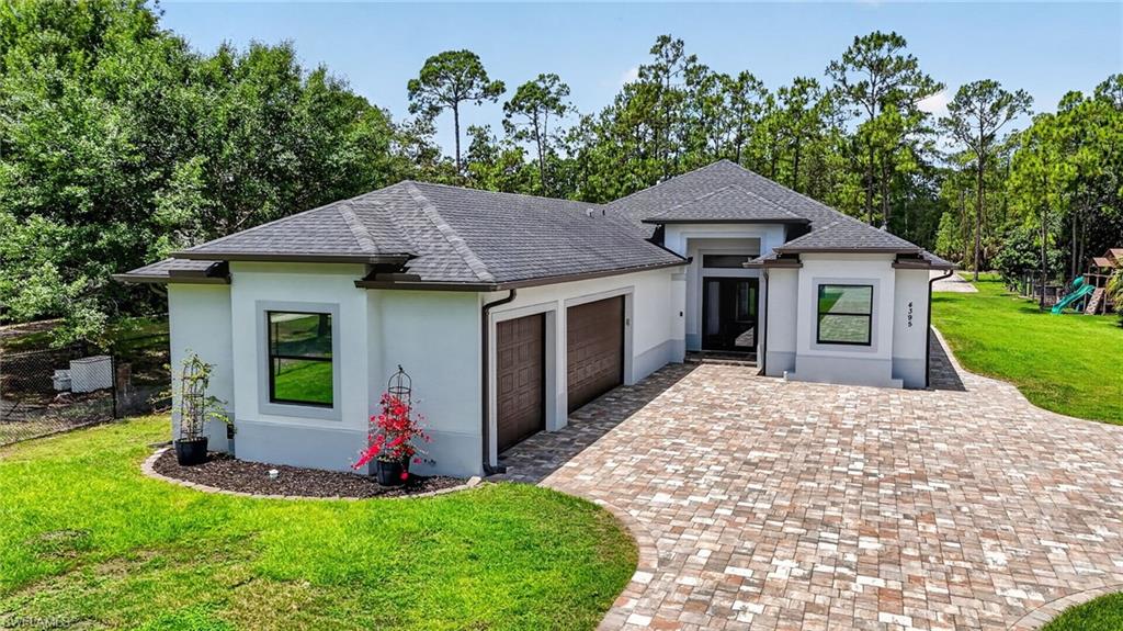 Contemporary single-story residence featuring a gray shingle roof and a paver driveway