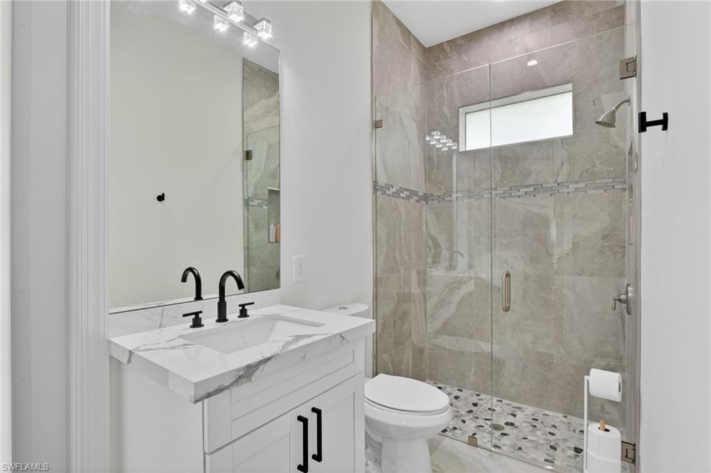 Contemporary bathroom featuring a frameless glass shower enclosure, large format tile shower walls, and a mosaic tile shower floor