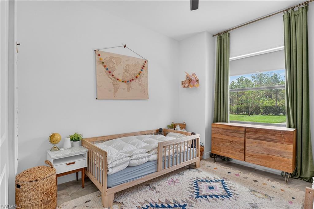 Bright room with a large window, light wood-finish flooring, and white walls