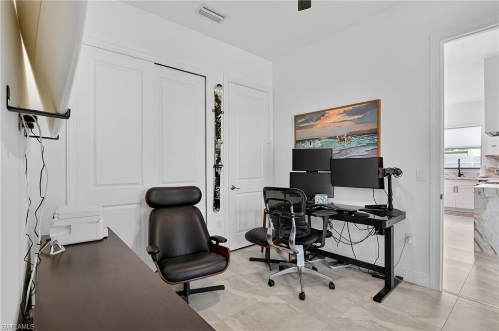 Interior room with light gray tile flooring, white walls, and a ceiling fan