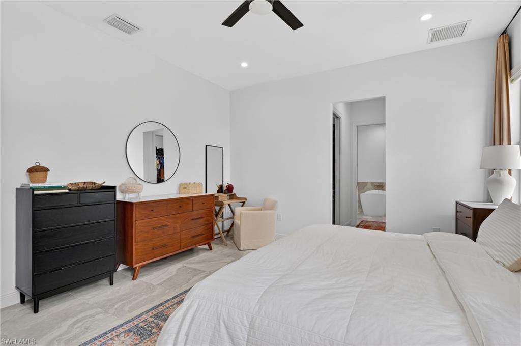 Spacious room featuring light-toned tile flooring, recessed lighting, and a dark-toned ceiling fan