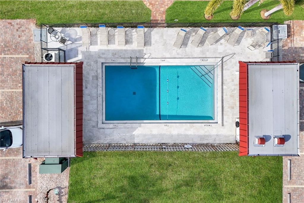 Community swimming pool with surrounding paver deck and ample lounge seating