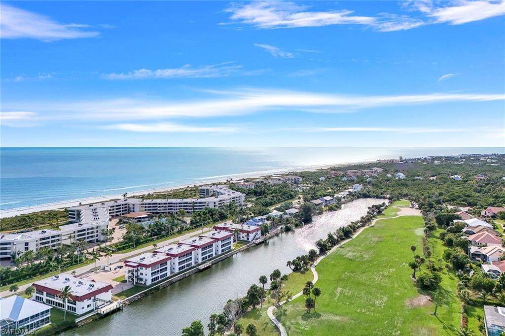 Aerial perspective showcasing beachfront properties alongside a canal and golf course