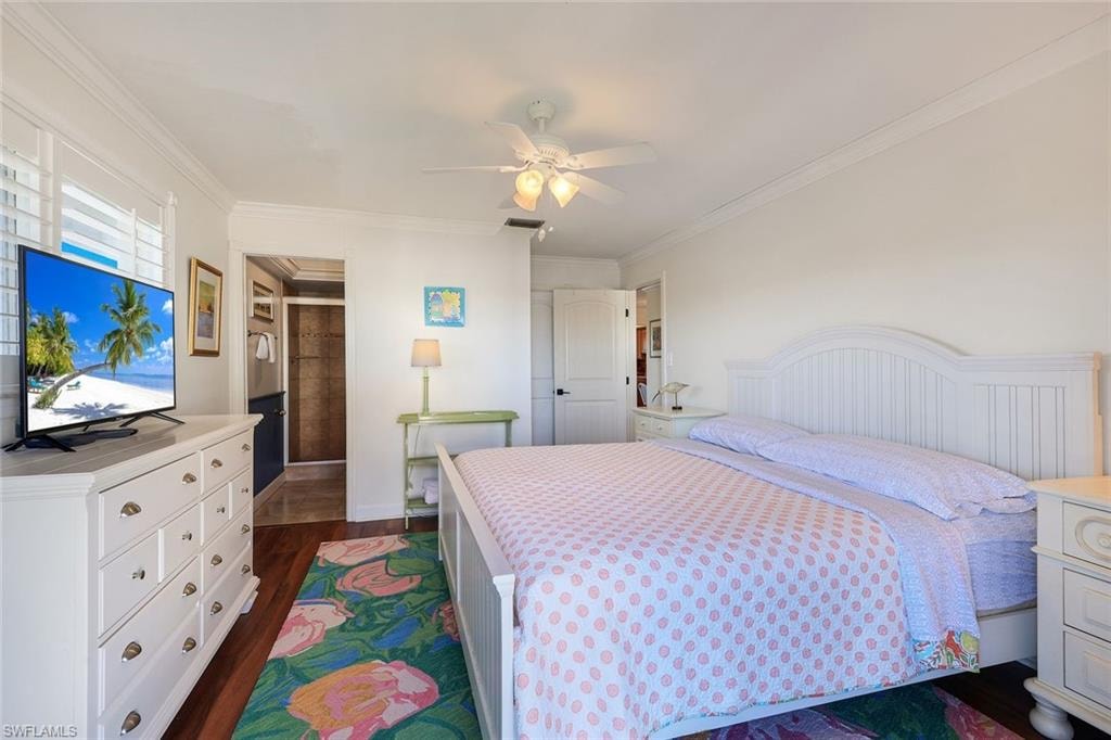 Bright interior featuring crown molding and rich wood-finish flooring