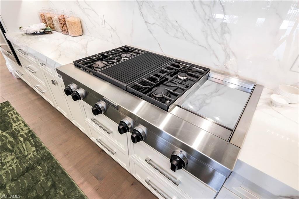 Four burner range with grill feature and griddle