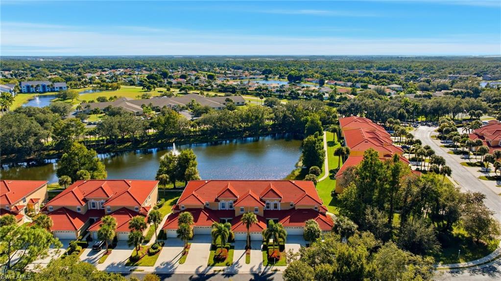 Drone / aerial view of a nearby body of water and a tree filled landscape