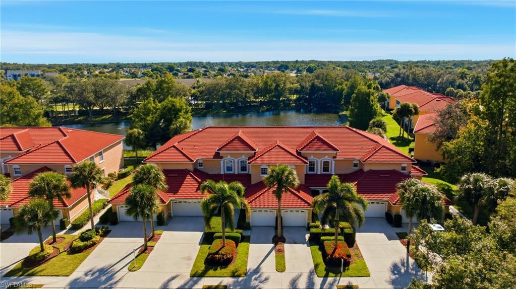 Drone / aerial view of a nearby body of water and a tree filled landscape