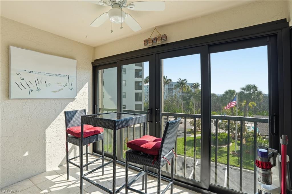 Balcony featuring a ceiling fan, textured wall finish, and sliding glass doors - Virtually Edited Image