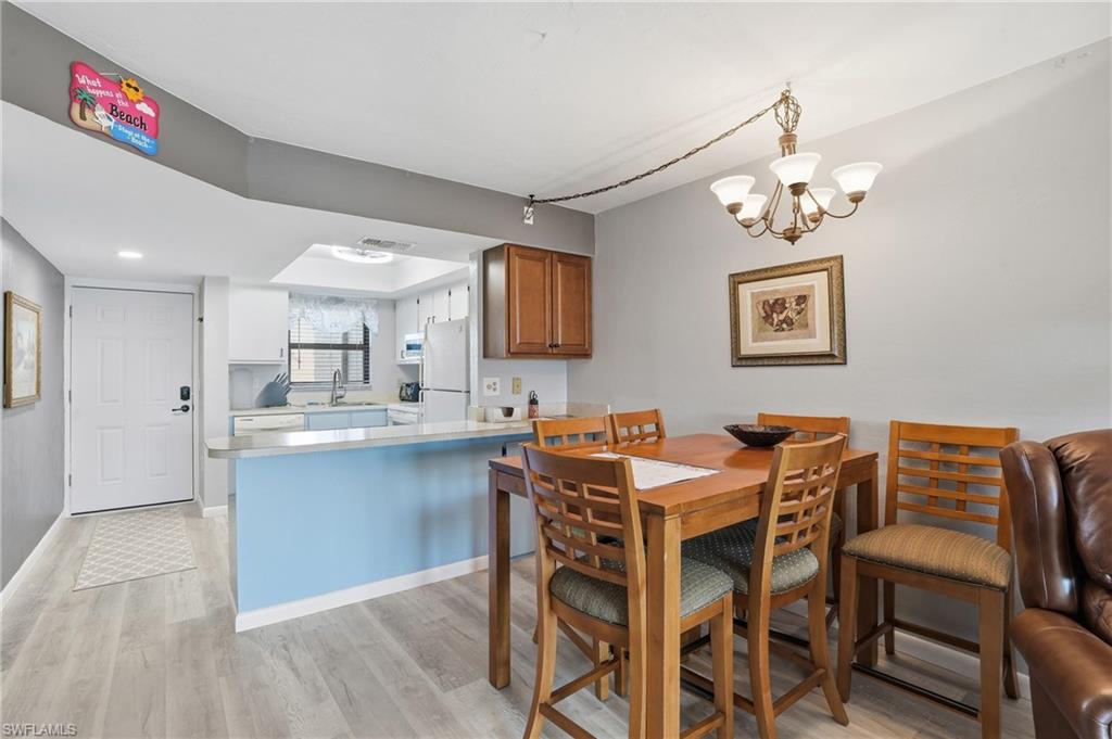 Kitchen and dining area featuring light wood-finish flooring - Virtually Edited Image