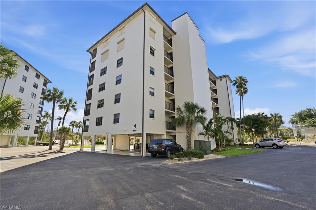Multi-story residential building featuring a white stucco exterior and dark-framed windows - Virtually Edited Image
