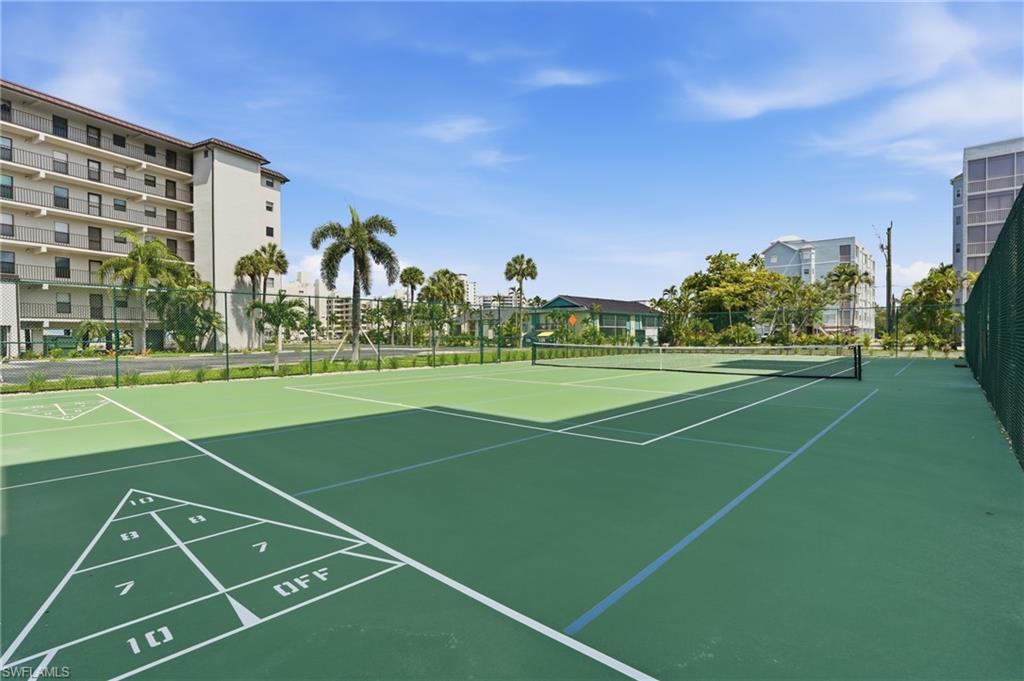 Green tennis court with white line markings and a black net - Virtually Edited Image