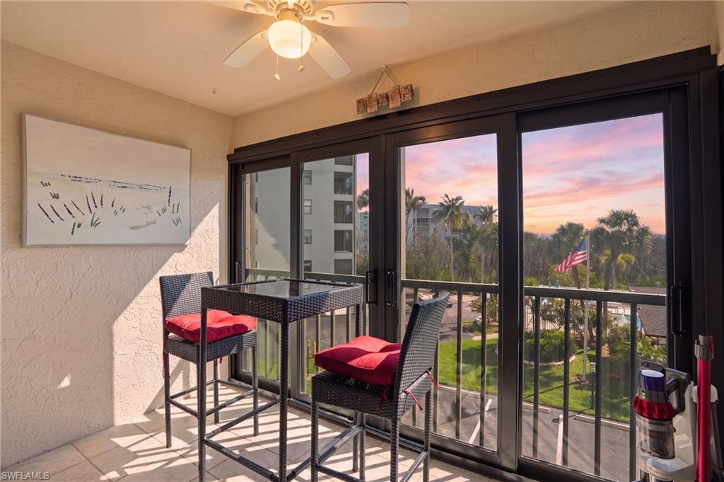 Private balcony featuring sliding glass doors, a ceiling fan, and a textured wall finish - Virtually Edited Image