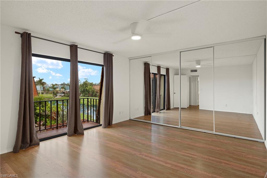 Bedroom featuring wood-finish flooring, a contemporary ceiling fan, and mirrored closet doors