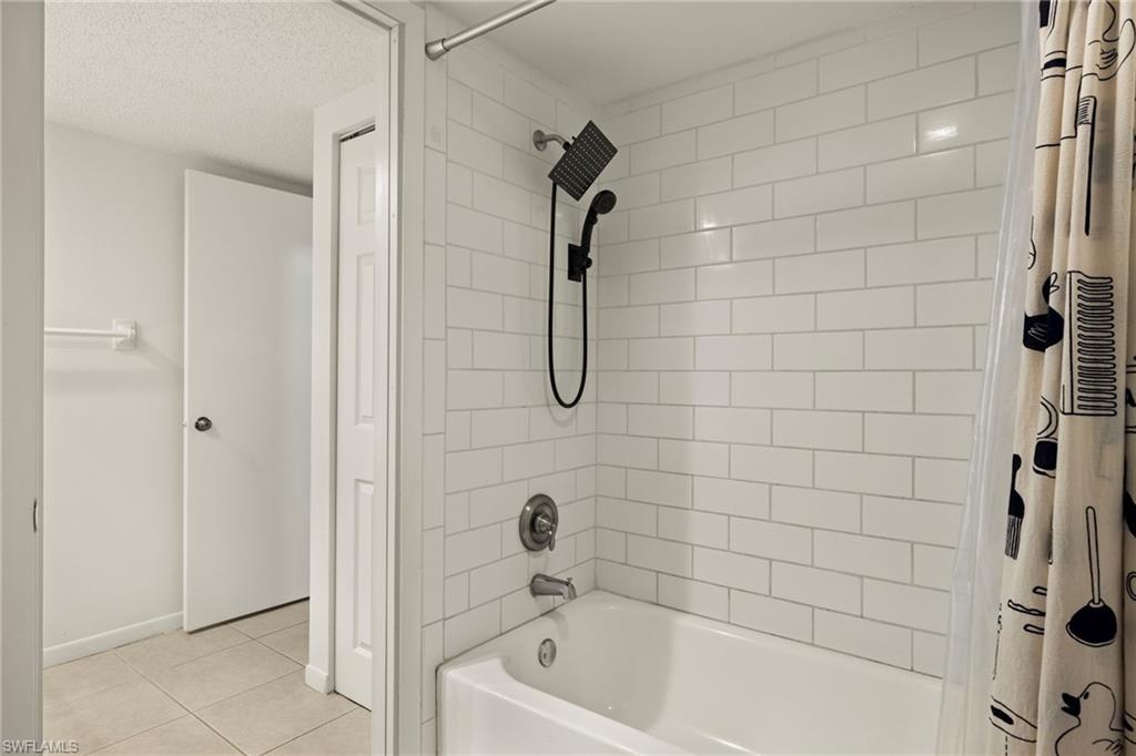 Bathtub with white subway tile surround and matte black shower fixtures