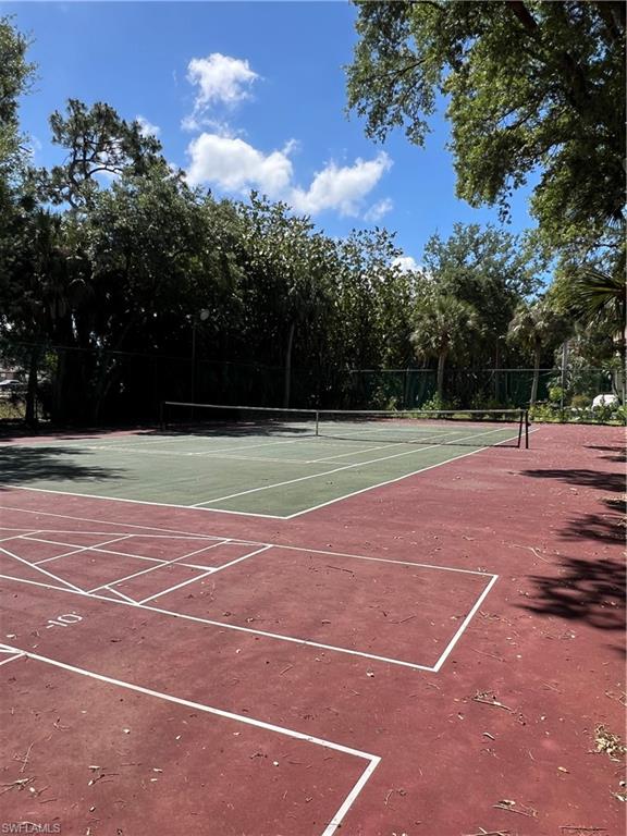 Sport court featuring a full-size tennis court and an adjacent shuffleboard court