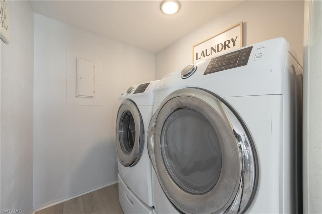 Dedicated laundry area featuring light wood-finish flooring and a ceiling-mounted recessed light