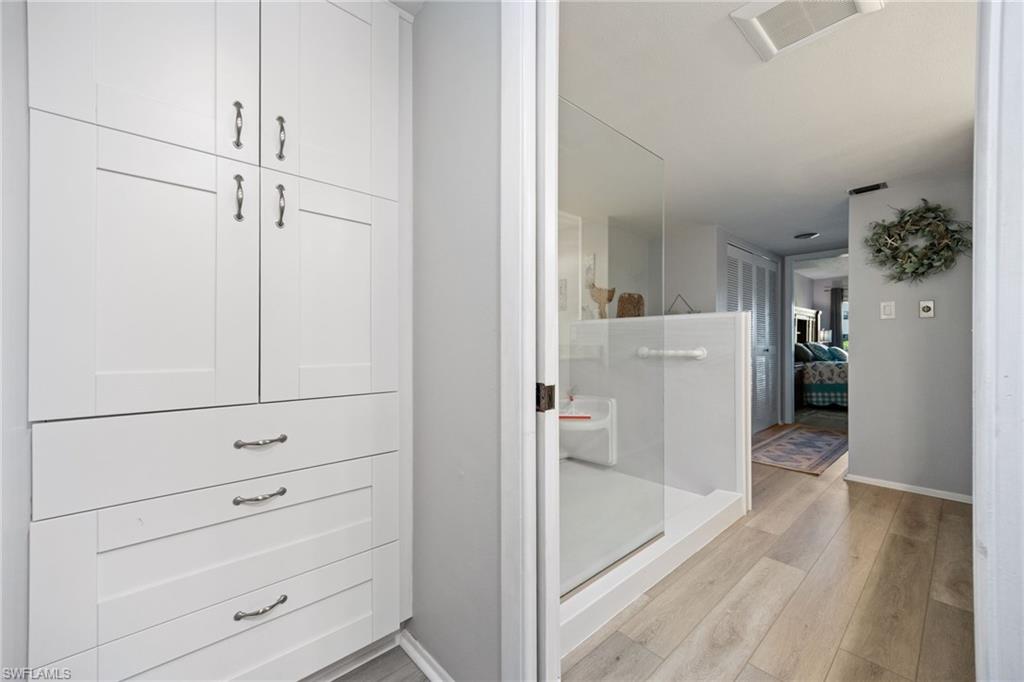 Built-in white cabinetry with polished hardware offers ample storage