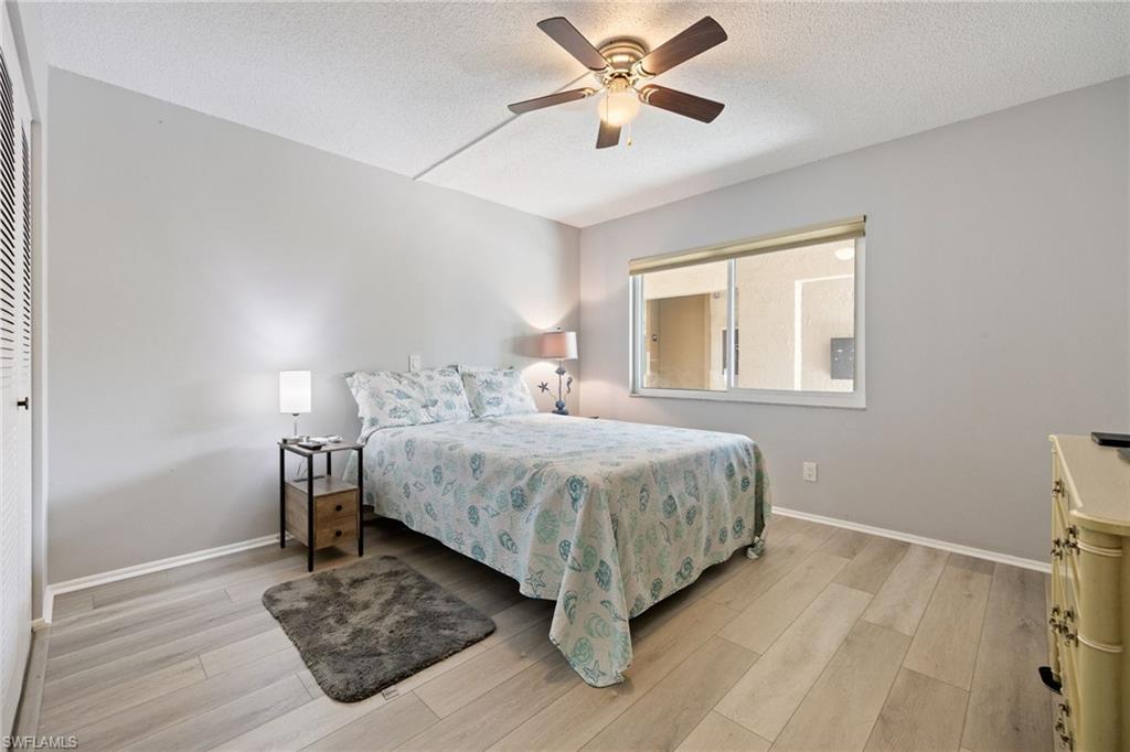 Room featuring light wood-finish flooring, a ceiling fan with integrated lighting, and a large window