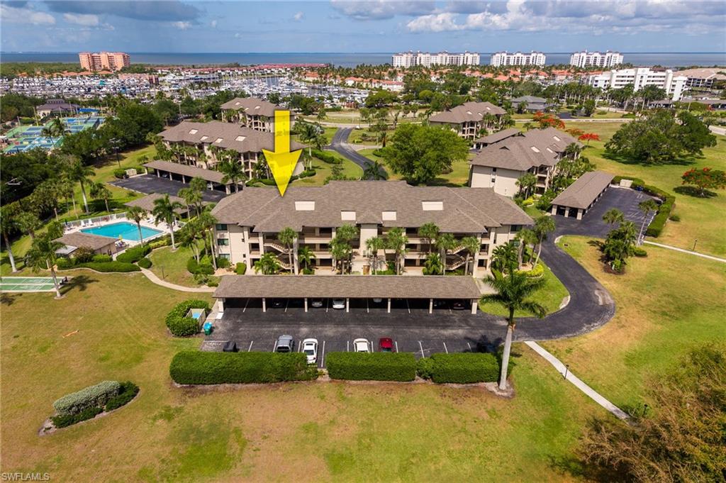 Multi-story residential building featuring covered parking and an outdoor swimming pool