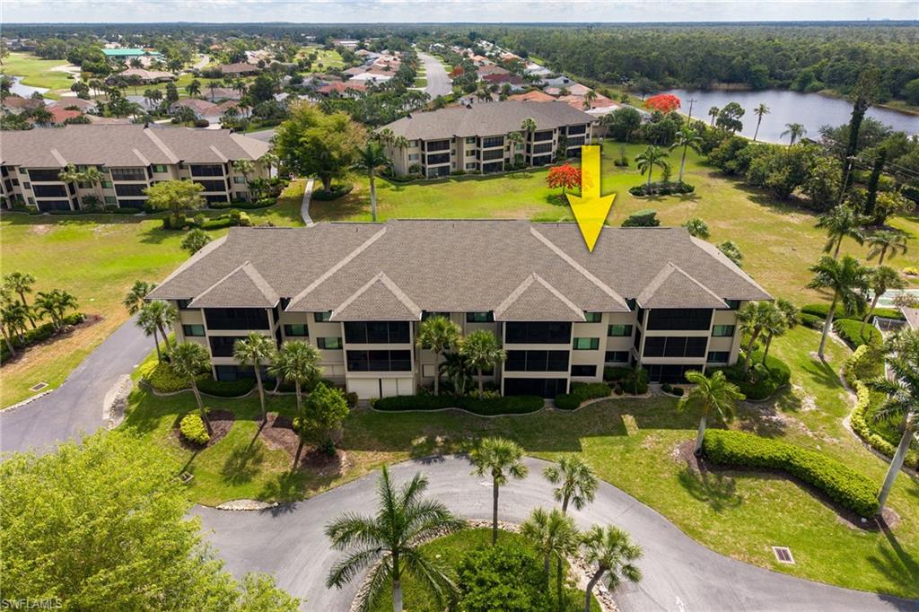 Multi-story condominium building featuring a shingled roof and screened lanais