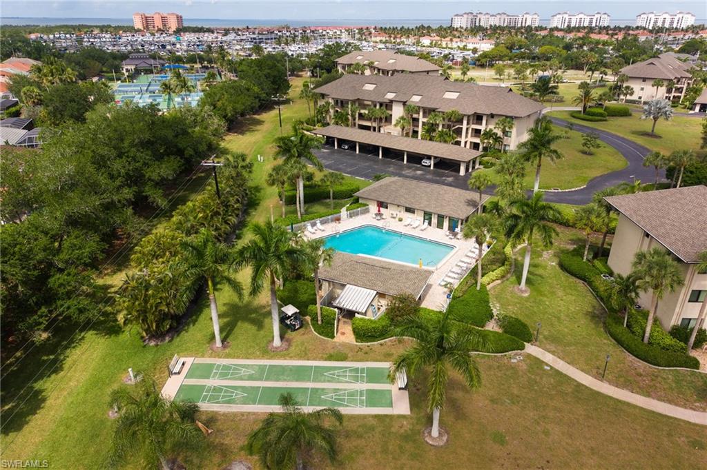 Community amenities featuring a swimming pool, shuffleboard courts, and mature landscaping