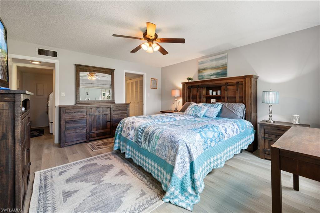 Spacious room featuring wood-finish flooring, a ceiling fan with integrated lighting, and neutral wall tones