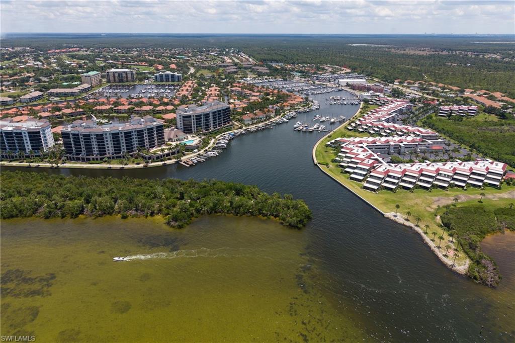 Waterfront community featuring a marina, residential buildings with multiple stories, and a natural aquatic setting