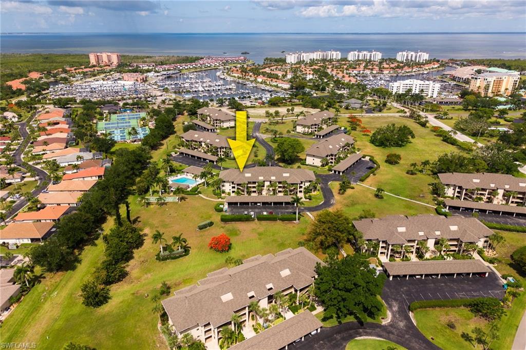 Community featuring multiple multi-story residential buildings with covered parking, an outdoor swimming pool, and tennis courts