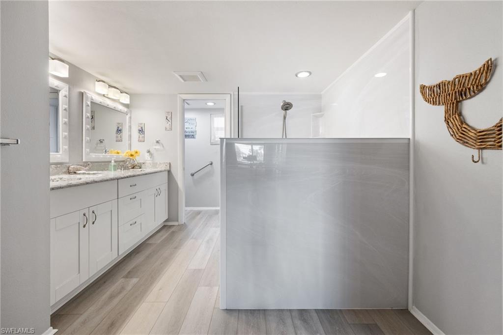 Modern bathroom featuring a dual vanity with white cabinetry and light-toned countertops