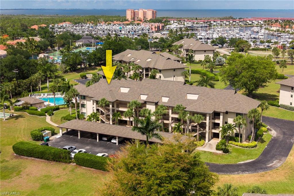 Multi-story condominium building featuring a shingle roof and multiple balconies
