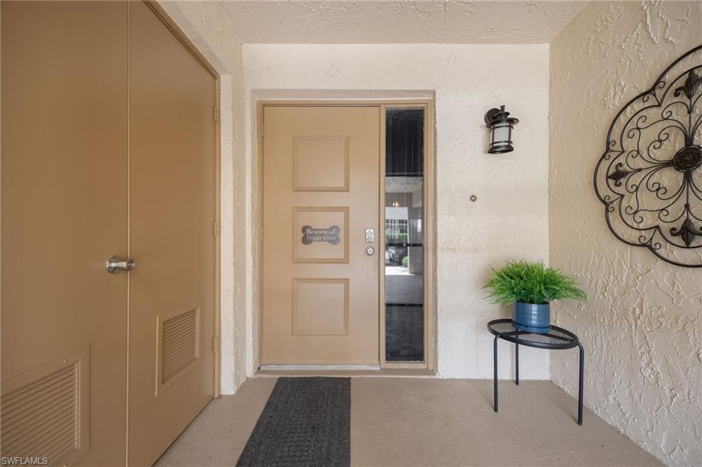 Entryway featuring a panel door with sidelite, exterior wall sconce, and textured wall finish
