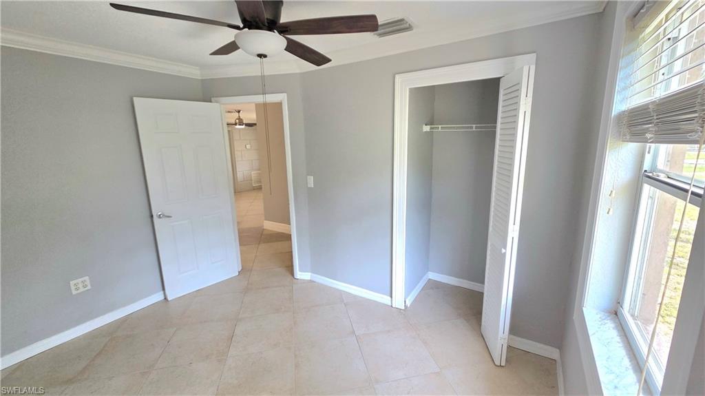 Bedroom #2 featuring  tile flooring, a ceiling fan with light fixture, and a window with horizontal blinds
