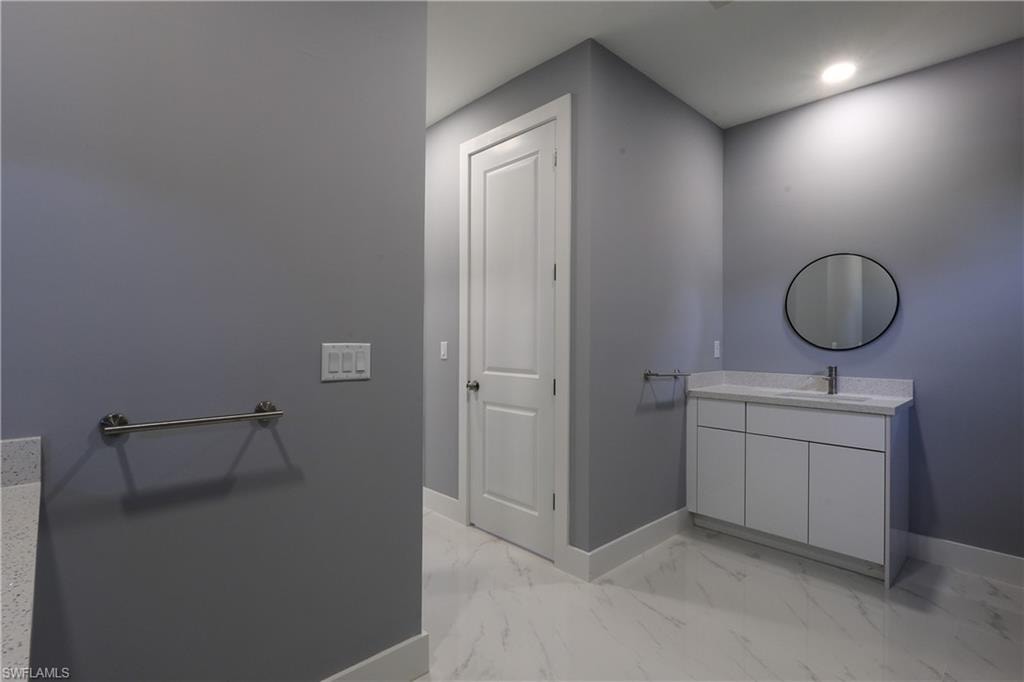 Bathroom with vanity and light marble finish floors