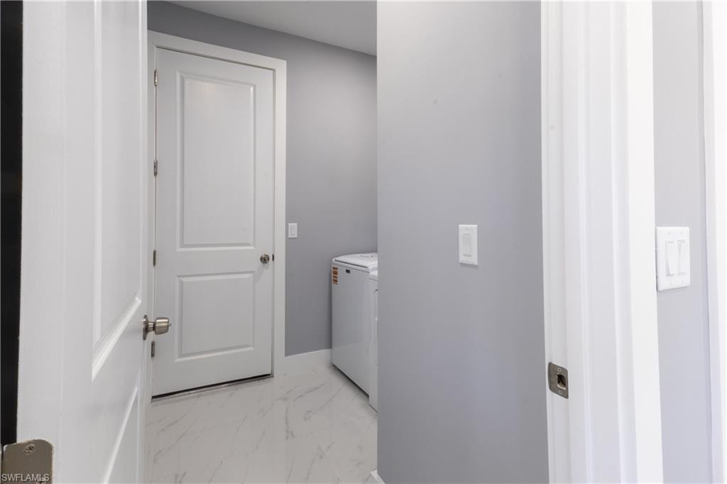 Laundry area with light marble finish floors and baseboards