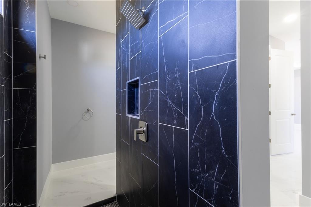 Full bathroom featuring a marble finish shower and marble finish floors