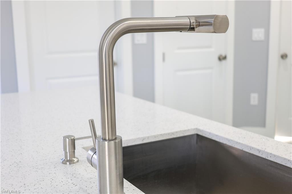 Kitchen view of a sink and light stone countertops