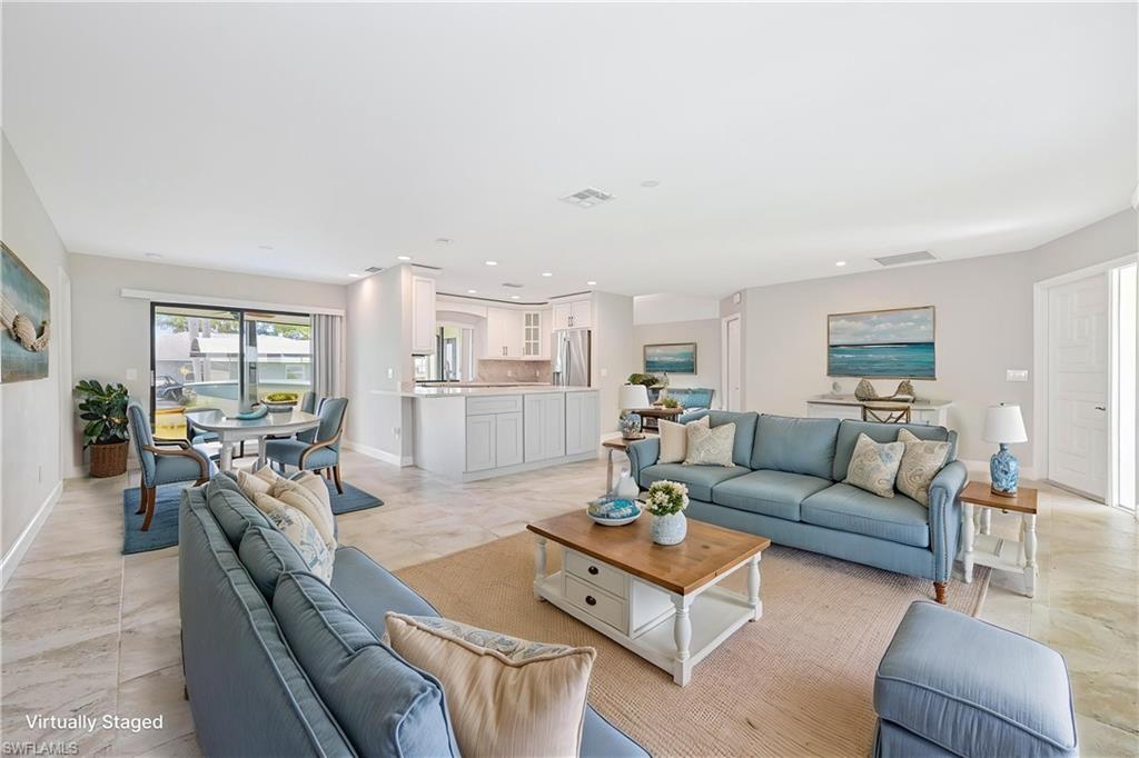 Open-concept living space featuring neutral tone tile flooring and light-toned walls