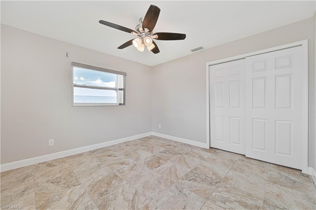 Room featuring large format multi-tone tile flooring, neutral wall tones, and a window with water scenery