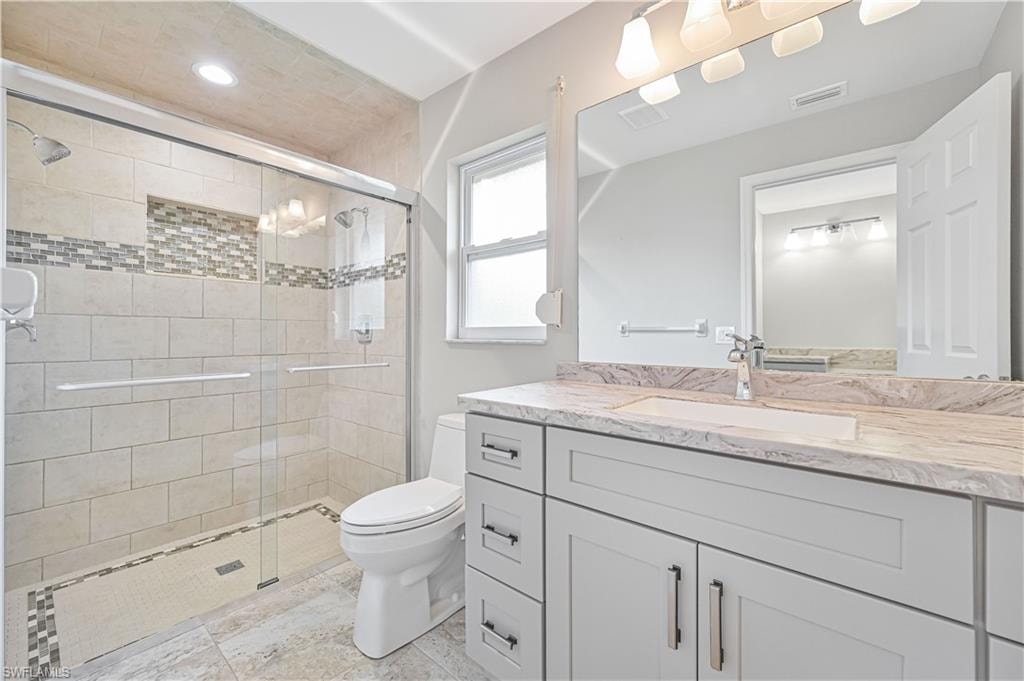 Bathroom featuring a glass-enclosed shower with subway tile, mosaic accent band, and recessed niche