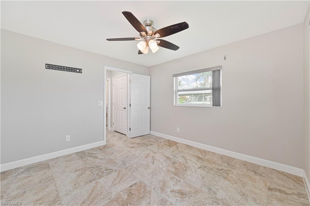 Room featuring neutral gray walls, large format tile flooring, and a ceiling fan with integrated lighting